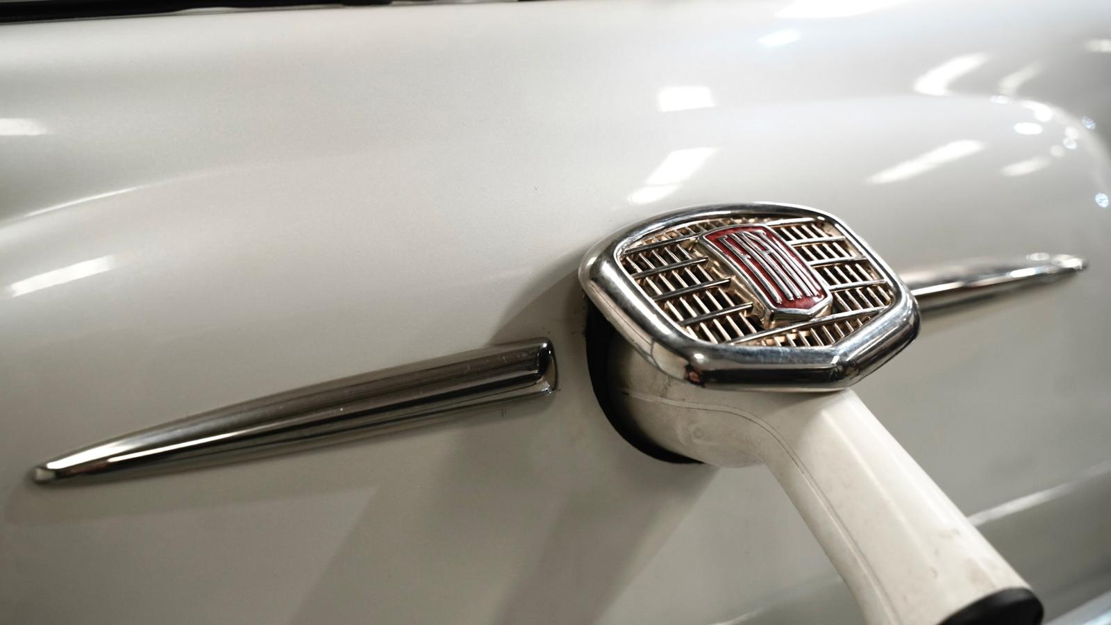 Classic Fiat 500 badge beside a charging connector — heritage meets electric